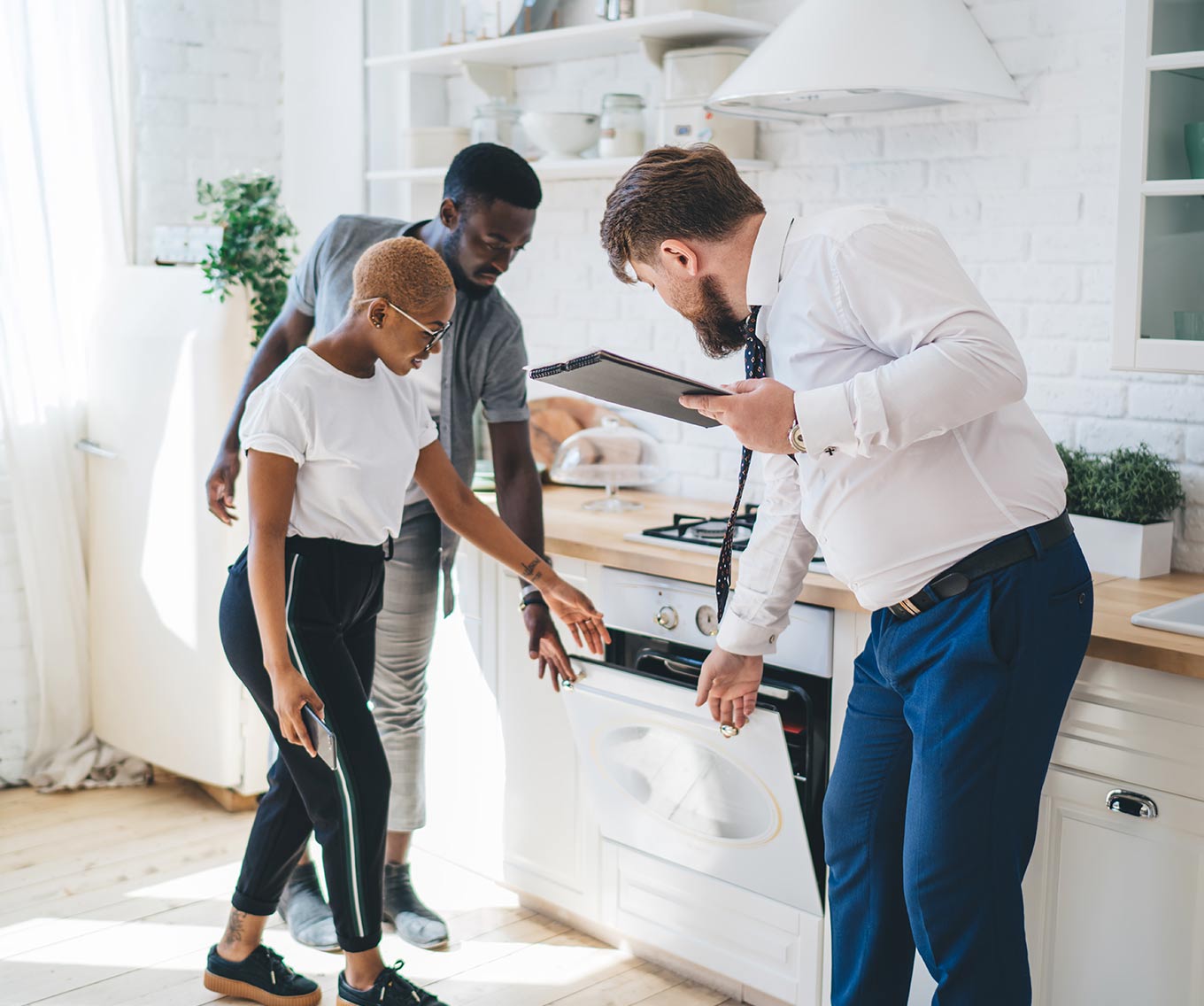 Couple Considers Renting vs. Owning With Realtor In Kitchen