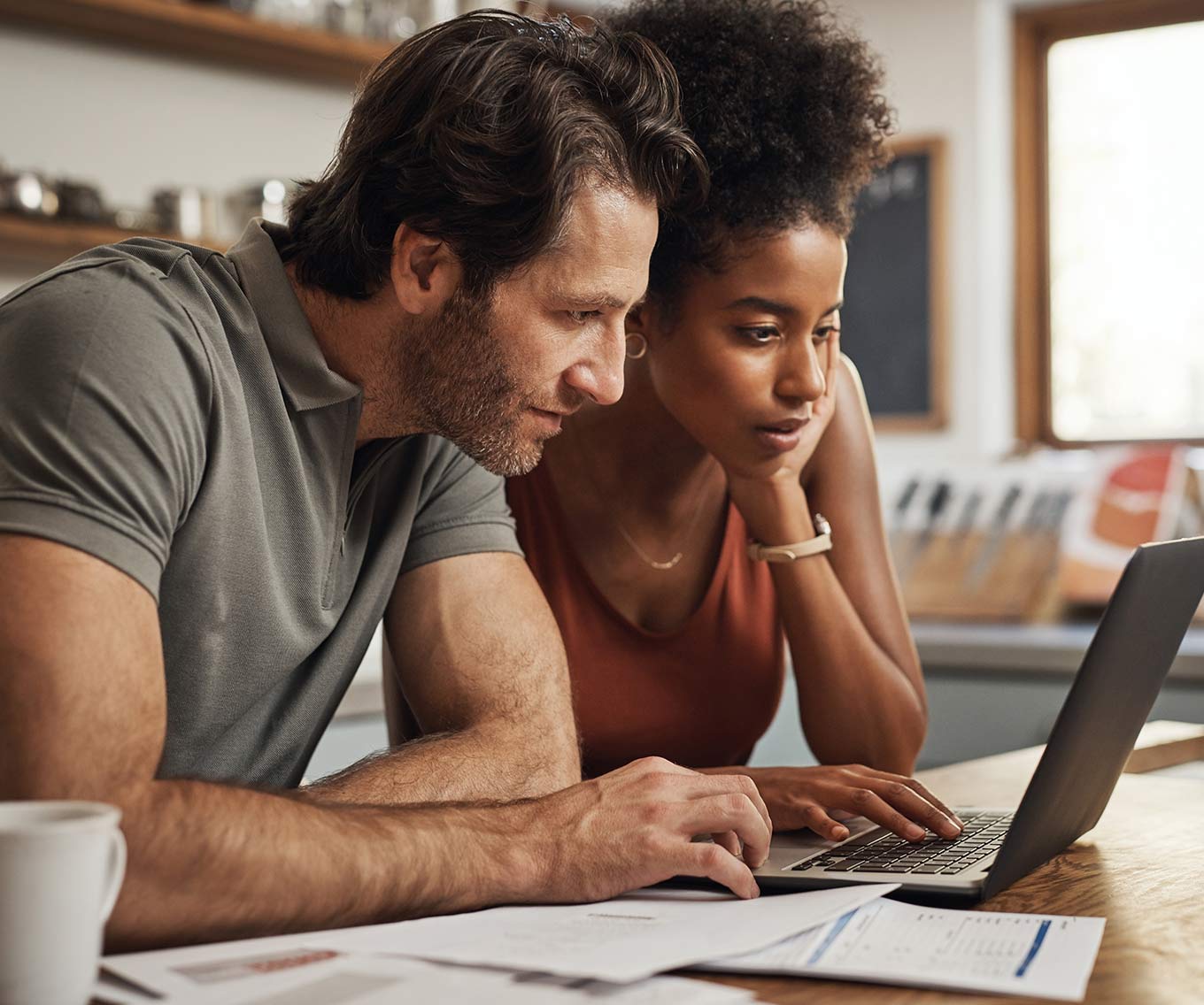 Couple researched renting out their primary residence together on a laptop.