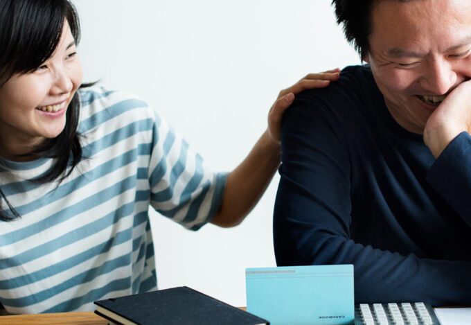 Couple sitting at kitchen table makes a household budget together.
